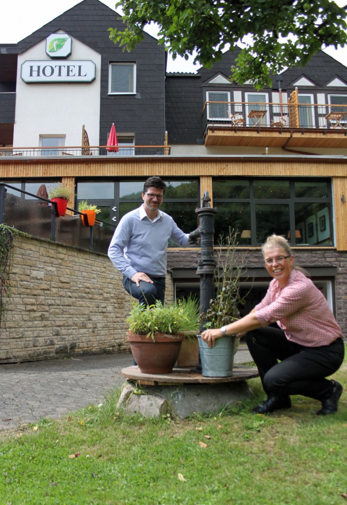 Annette und Jörg Treichel vor ihrem Biohotel am Brunnen in dem kleinen Garten. Foto: Silke Liebig-Braunholz